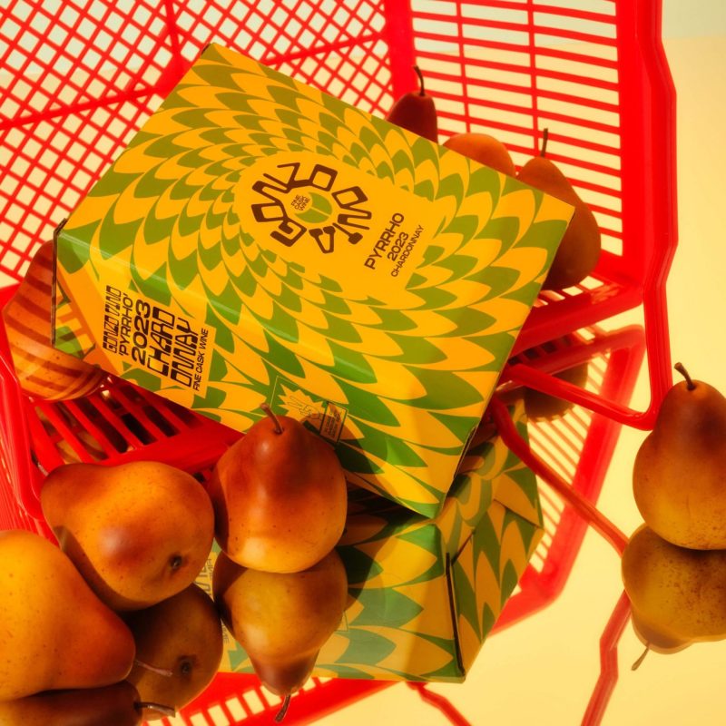 a cask of gonzo vino chardonnay sitting in a red shopping basket with some pears